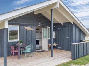 a shed with a table and chairs on a deck at Holiday Home Estella - 500m to the fjord by Interhome in Havrvig