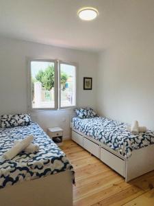 Un dormitorio con dos camas y una ventana. en Évasion méditerranéenne bas de villa Cath, jardin privé, parking, en Sanary-sur-Mer