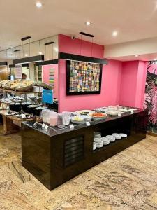 a buffet in a restaurant with a pink wall at Atlantis Copacabana Hotel in Rio de Janeiro