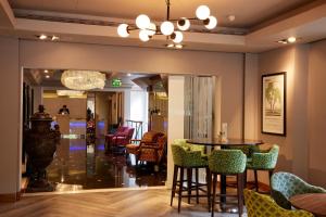 a dining room with a table and chairs at Thistle London Hyde Park Kensington Gardens in London +19 photos