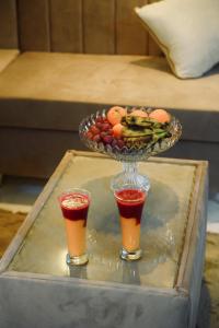 a tray with a bowl of fruit and two drinks at Paradise House Holiday in Luxor