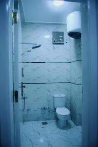a white bathroom with a toilet and a sink at pradise house holday in Banī Ghālib