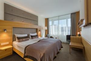 a hotel room with a large bed and a large window at Continental Hotel Lausanne in Lausanne