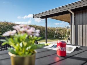 比耶勒高Holiday Home Aiske - from the sea by Interhome的一罐可乐放在桌子上，旁边还有一株植物