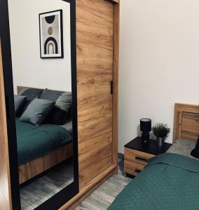 einen Spiegel in einem Schlafzimmer mit einem Bett in der Unterkunft Apartament 87 in Jelenia Góra