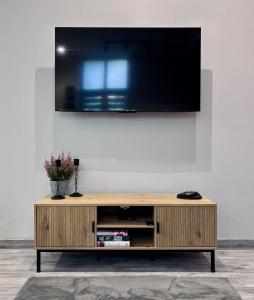 ein hölzernes Entertainment-Center mit einem Flachbildfernseher an der Wand in der Unterkunft Apartament 87 in Jelenia Góra