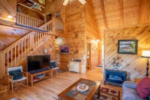 a living room with a couch and a tv in a log cabin at Serene & Cozy 3bd Cabin- Dogs Welcome, Hot Tub, Mins to Parkway in West Jefferson