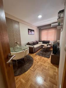 a living room with a couch and a glass table at Mirkovic Lux apartman in Niš