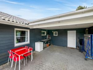 比耶勒高Holiday Home Ludvig - from the sea by Interhome的房屋前方的庭院配有红色的桌椅