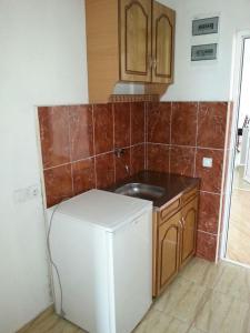 a kitchen with a white refrigerator and a sink at Apartments Dukat in Ulcinj