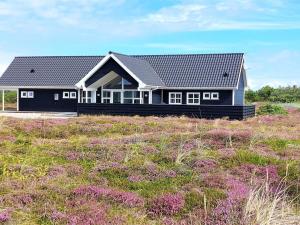 ein Haus auf einem Feld mit lila Blumen in der Unterkunft Holiday Home Eliena - 500m from the sea by Interhome in Bjerregård