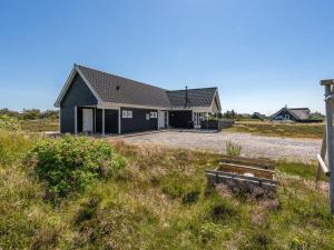 ein Haus auf einem grasbewachsenen Hügel mit einem Haus in der Unterkunft Holiday Home Eliena - 500m from the sea by Interhome in Bjerregård + 17 Fotos