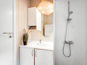ein Badezimmer mit Waschbecken und Dusche in der Unterkunft Holiday Home Andrie - 800m from the sea by Interhome in Hvide Sande