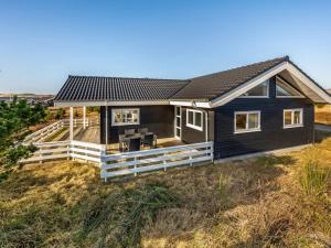 a house on the beach with a fence at Holiday Home Niesina - from the sea by Interhome in Bjerregård