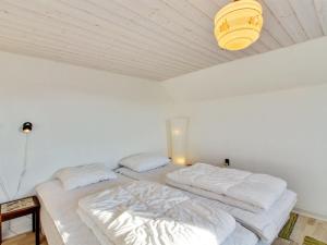 Dos camas en una habitación blanca con techo. en Apartment Arli - 800m from the sea by Interhome, en Bjerregård