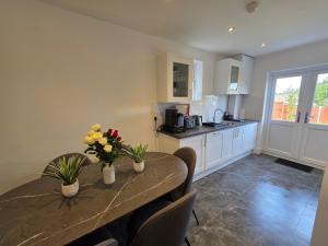 a kitchen with a table with flowers on it at 5 Beds 7 guests Private Garden Free Parking in Nottingham
