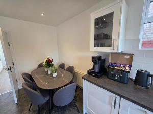 a kitchen with a table with chairs and a coffee maker at 5 Beds 7 guests Private Garden Free Parking in Nottingham +8 photos