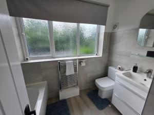 a bathroom with a toilet and a sink and a window at 5 Beds 7 guests Private Garden Free Parking in Nottingham