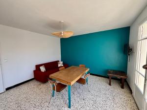 a living room with a table and a red couch at Chez Mamé Marie in Fraissé-des-Corbières