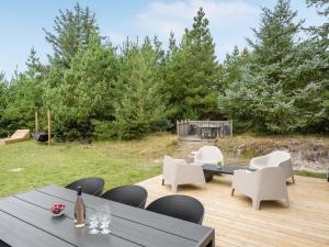 a patio with a table and chairs and trees at Holiday Home Doreen - from the sea by Interhome in Bjerregård