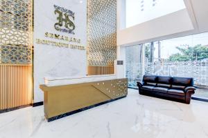 a lobby of a building with a couch in front of a sign at Townhouse OAK Near The Park Mall Semarang Formerly Semarang Boutique Hotel in Semarang