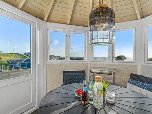 una sala da pranzo con tavolo e finestre di Holiday Home Aksinja - 250m to the inlet by Interhome a Lemvig