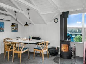 een eetkamer met een open haard en een tafel en stoelen bij Holiday Home Aksinja - 250m to the inlet by Interhome in Lemvig