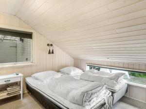 een bed in een kleine kamer met een raam bij Holiday Home Aksinja - 250m to the inlet by Interhome in Lemvig