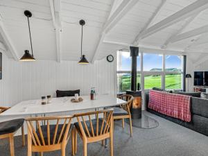 een woonkamer met een tafel, stoelen en een bank bij Holiday Home Aksinja - 250m to the inlet by Interhome in Lemvig