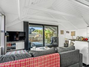 een woonkamer met een bank en een tv bij Holiday Home Aksinja - 250m to the inlet by Interhome in Lemvig +18 foto's