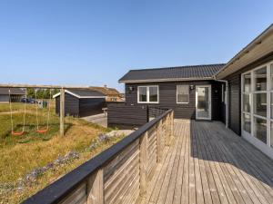 a house with a wooden deck next to a house at Holiday Home Withger - 300m from the sea by Interhome in Harboør