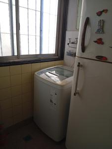 a kitchen with a refrigerator and a washing machine at Departamento sobre Boulevard Oroño in Rosario