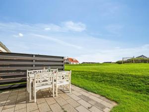 a table and chairs on a patio with a field at Apartment Smeralda - 200m from the sea by Interhome in Lemvig