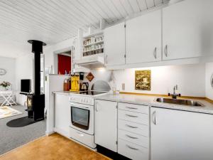 a kitchen with white cabinets and a sink at Apartment Smeralda - 200m from the sea by Interhome in Lemvig