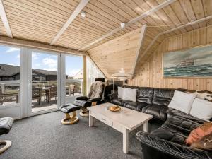 a living room with a couch and a table at Holiday Home Agga - 200m from the sea by Interhome in Harboør +25 photos