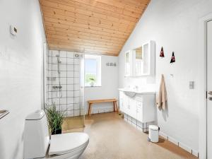 a bathroom with a toilet and a sink at Holiday Home Benthe - from the sea by Interhome in Ulfborg