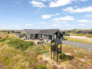 a house on the side of a road with a playground at Holiday Home Ennie - from the sea by Interhome in Bjerregård