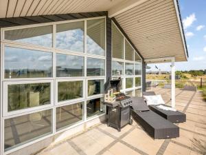 a screened in porch with a couch and a stove at Holiday Home Ennie - from the sea by Interhome in Bjerregård