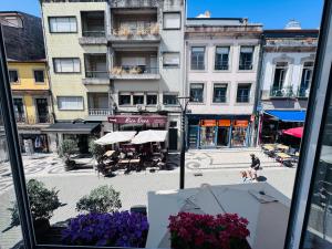 a view of a city street from a window with purple flowers at Majestic Hostel Porto in Porto +15 photos
