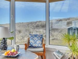 une pièce avec une table, une chaise et des fenêtres dans l'établissement Holiday Home Pauli - 75m from the sea by Interhome, à Harboør