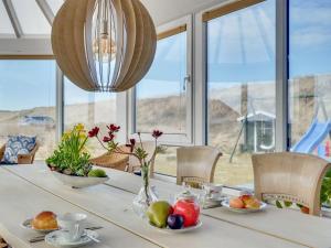 une salle à manger avec une table avec des fruits et un lustre dans l'établissement Holiday Home Pauli - 75m from the sea by Interhome, à Harboør 23 autres photos