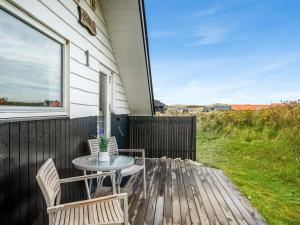 a patio with a table and chairs on a deck at Holiday Home Olesia - 250m from the sea by Interhome in Harboør +23 photos