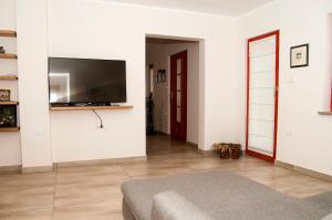 a living room with a flat screen tv on a wall at Bed & Fishing House in Slap ob Idrijci