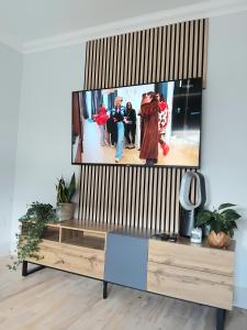 a flat screen tv sitting on top of a entertainment center at Room in bungalow in Alness