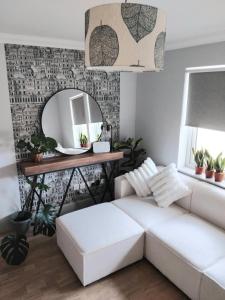 a living room with a white couch and a mirror at Room in bungalow in Alness