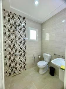 a bathroom with a toilet and a sink and a tub at Dar kenza in Ouled Yaneg