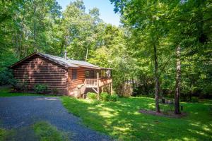 una baita di tronchi in mezzo a un cortile di Updated Cabin with 2 primary suites, hot tub, spacious covered porch a Fleetwood