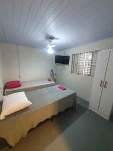 a room with a bed and a tv in it at Morá Coliving in Cachoeirinha
