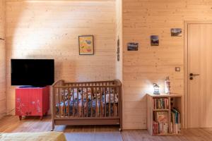 Habitación con cuna y TV. en Le petit Ranch, en Le Reposoir