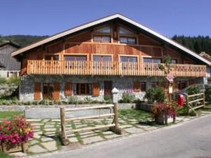 ein großes Holzhaus mit einem Zaun davor in der Unterkunft Appartement 3 pièces - 6 pers - Proche pistes et commerces, navette gratuite - FR-1-572-19 in Arâches-la-Frasse